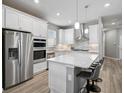 Modern kitchen featuring stainless steel appliances, white cabinets, and a center island with seating at 8313 Ocean Tides Cv, Parrish, FL 34219