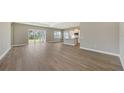 Open-concept living area showcasing wood-look floors, recessed lighting, and sliding glass doors to the backyard at 10027 Cross River Trl, Parrish, FL 34219