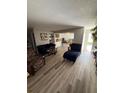 Open concept living room with hardwood floors, comfortable seating and view to the kitchen at 1147 Longfellow Rd # 157C, Sarasota, FL 34243