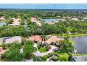 Stunning aerial view of the home surrounded by lush trees and a beautiful lake at 11551 30Th E Cv, Parrish, FL 34219