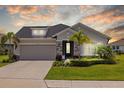 Charming single-story home with a two car garage, stone accents, and lush landscaping at 11719 Chevelon Ln, Parrish, FL 34219