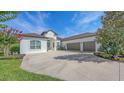 The home's front exterior features a wide driveway, a three car garage, and a well maintained lawn at 13130 50Th E Ct, Parrish, FL 34219
