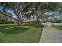 Quaint single-story house featuring mature landscaping, a long driveway, and a lush green lawn at 13612 11Th E Ter, Bradenton, FL 34212
