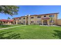 The condo building features yellow walls, a red tile roof, and a well-manicured lawn at 1431 57Th W St # 1431, Bradenton, FL 34209