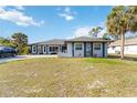 Charming single-story home with a well-maintained lawn and mature palm trees at 18033 Edgewater Dr, Port Charlotte, FL 33948