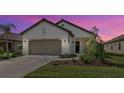 Charming single-story home with well-maintained landscaping, a two-car garage, and neutral exterior paint at 208 Potenza Loop, Nokomis, FL 34275