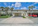 Condo complex with covered parking featuring individual storage units and access to upper-level units via stairs at 208 Silver Lake Dr # 101, Venice, FL 34292