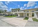 Exterior shot of a condo community featuring covered parking, palm trees, and well-maintained landscaping at 208 Silver Lake Dr # 101, Venice, FL 34292