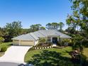 Beautiful single-story home boasts lush landscaping, a three-car garage, and a well-manicured lawn at 2196 Muskogee Trl, Nokomis, FL 34275