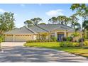 Charming single-story home featuring a three-car garage, lush landscaping, and a well-manicured lawn at 2196 Muskogee Trl, Nokomis, FL 34275