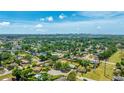 Expansive aerial view showcasing a neighborhood with mature trees and distant city skyline views at 2237 Lockwood Meadows Cir, Sarasota, FL 34234