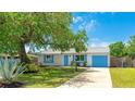 Cozy home featuring vibrant blue accents on the shutters and garage door, complemented by a lush green lawn at 2237 Lockwood Meadows Cir, Sarasota, FL 34234