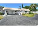 Charming single-story home featuring a stone accent wall, well-kept lawn, and a welcoming carport at 2417 Riverbluff Pkwy # 235, Sarasota, FL 34231