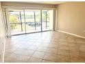 Bright living room with tiled floor, sliding glass doors to balcony, and neutral walls at 2938 Clark Rd # 203, Sarasota, FL 34231
