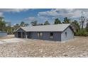 An exterior view shows the home's metal roof, xeriscaped front yard, and screened-in porch at 31860 Taylor Grade Rd, Duette, FL 34219