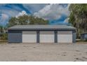 A three car garage has matching siding and roofing and three white garage doors at 31860 Taylor Grade Rd, Duette, FL 34219