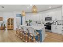 Modern kitchen with white cabinets, a large island with seating, and stainless steel appliances at 3443 74Th Avenue E Cir, Sarasota, FL 34243