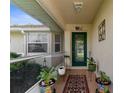 Cozy front porch featuring tiled floors, potted plants, and a welcoming entrance door at 3459 Lotus Rd, North Port, FL 34291