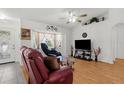 Bright living room with hardwood floors, decorative accents, and large windows at 3459 Lotus Rd, North Port, FL 34291