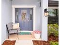 Inviting front porch features a cozy bench, plants and wreath, welcoming guests at 4509 95Th E Ter, Parrish, FL 34219