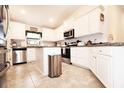 Bright kitchen featuring granite countertops, stainless steel appliances, and white cabinets, ideal for cooking and entertaining at 4509 95Th E Ter, Parrish, FL 34219