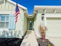 Inviting entryway with a teal front door, sidelight window, and neatly landscaped garden at 4578 Cedar Brush Ter, Sarasota, FL 34243
