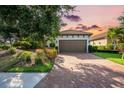 Charming home with a two-car garage, lovely landscaping, brick driveway, and tile roof at 4704 Stafford Ct, Palmetto, FL 34221