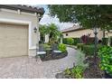 Inviting outdoor seating area with lovely landscaping and a serene brick path at 5019 Serata Dr, Lakewood Ranch, FL 34211