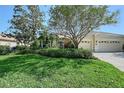 The exterior presents lush landscaping, a well-manicured lawn, and a two-car garage, enhancing its curb appeal at 5032 Timber Chase Way, Sarasota, FL 34238