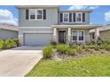 Charming two-story home featuring stone accents, a two-car garage, and a well-manicured front yard at 5715 Woodland Sage Dr, Sarasota, FL 34238