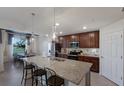 Modern kitchen features a large island, stainless steel appliances, and dark wood cabinets with stone countertops at 5720 Palmer Cir # 103, Bradenton, FL 34211