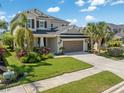 Attractive two-story home with well-maintained lawn, mature palm trees, and a two-car garage at 5749 Sunflower Cir, Sarasota, FL 34238