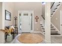 Inviting foyer with a high ceiling, stylish staircase, and a decorative round area rug at 5749 Sunflower Cir, Sarasota, FL 34238