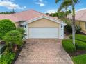 Exterior shot of a home featuring a well maintained brick driveway and an attached two car garage with carriage doors at 6209 Erice St, Venice, FL 34293
