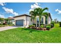 Charming home featuring a lush lawn, tropical palm trees, and a paved driveway at 6267 Crested Eagle Ln, Nokomis, FL 34275