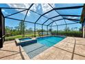 Screened-in pool and spa overlooking the lush backyard and serene water views at 6267 Crested Eagle Ln, Nokomis, FL 34275