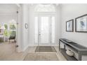 Bright foyer with a modern console table, neutral decor, tile floors, and a clear view to adjacent room at 7016 Lennox Pl, University Park, FL 34201