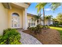 Inviting front entrance with manicured landscaping, a charming walkway, and a bright, welcoming facade at 7016 Lennox Pl, University Park, FL 34201