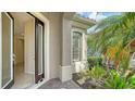 A bright entryway with an open door and a view of the lush landscaping outside at 7158 Westhill Ct, Lakewood Ranch, FL 34202