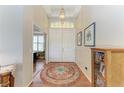 Bright foyer with a decorative rug, chandelier, and wooden floors creating a warm entrance at 8136 Snowy Egret Pl, Bradenton, FL 34202