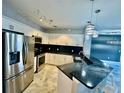 Bright kitchen features modern appliances, granite counters, and trendy lighting fixtures at 8325 38Th Street E Cir # 107, Sarasota, FL 34243