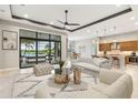 Stylishly furnished living room with tile flooring, a ceiling fan, and a view of the pool at 8936 Artisan Way, Sarasota, FL 34240