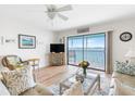 Bright living room featuring a ceiling fan, comfortable seating, and sliding doors that offer beautiful water views at 901 Gulf S Dr # 14, Bradenton Beach, FL 34217