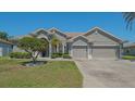 Charming single-story home with a well-manicured lawn, mature landscaping, and a three-car garage at 1085 Mallard Marsh Dr, Osprey, FL 34229
