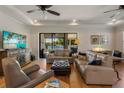 Elegant living room with neutral tones, tray ceiling, and beautiful view of the lake through sliding glass doors at 12740 Del Corso Loop, Lakewood Ranch, FL 34211
