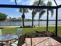 Outdoor patio with brick flooring features a gorgeous water view and tropical landscaping at 13724 Quinta St, Venice, FL 34293