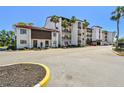 Charming condo building with Spanish-style architecture and mature palm trees at 1624 Stickney Point Rd # 24-206, Sarasota, FL 34231