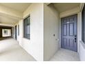 A gray front door with unit number on an outdoor hallway that has a view of an opening to the outside at 18114 Gawthrop Dr # 306, Bradenton, FL 34211