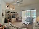 Bright living room with a view of the pool and outdoor area through large sliding glass doors and vertical blinds at 18513 Placid Ave, Port Charlotte, FL 33948