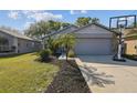 Charming single-story home with a two-car garage, well-manicured lawn, and a basketball hoop at 206 Bedford St, Oldsmar, FL 34677